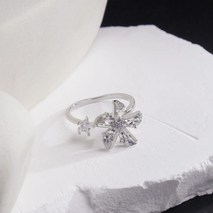 Feiner verstellbarer Blumenring in Silber mit Zirkonia-Blüte und Stern auf weißem Stein