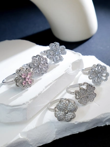 Close-up of rotating lucky clover rings with sparkling zircon and silver flower details