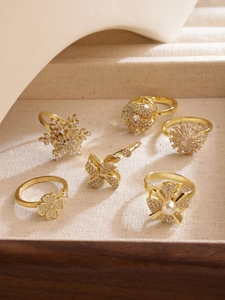 Detalle macro de anillos dorados con girasoles de circón y diseños de molinos giratorios