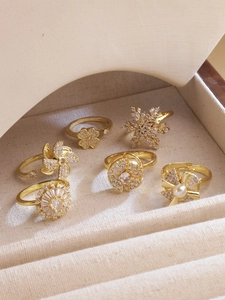 Detalle de anillos giratorios dorados con tréboles y copos de nieve de circón brillante