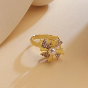 Elegante anillo giratorio de molinillo dorado con circonitas y una perla blanca