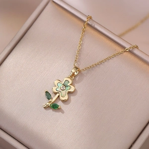 Elegante goldene Blumenhalskette mit grünen Perlmutt-Blättern und Zirkon-Stein