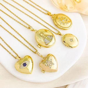 Gold locket necklace collection with heart and oval pendants on a white stone tray