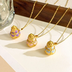 Three elegant gold gourd pendant necklaces with colorful enamel inlay on wood stand