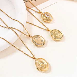 Detail of four golden oval locket necklaces with star, beetle, and pearl designs