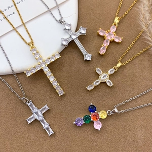 Chic gold and silver cross necklaces with colorful zircon stones on a soft brown background