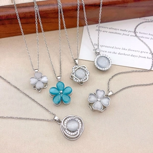 Elegant cat eye stone flower necklaces in light gray and blue on linen background