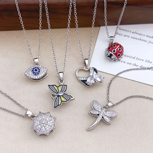 Rotating Evil Eye and colorful butterfly pendant necklaces in silver-plated stainless steel