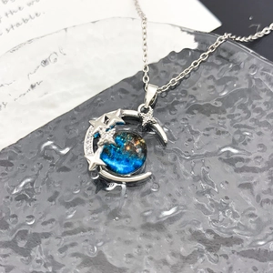 Collana con pendente a luna d'argento e sfera di vetro blu con motivo cielo stellato
