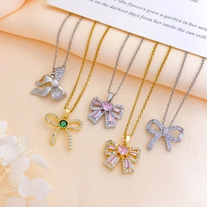 Elegant bow zircon necklaces set in gold and silver finish on silk background