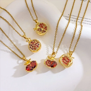 Vintage 18K gold plated pomegranate necklaces set with red zircon stones on display