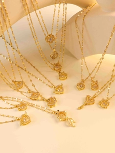 Detailansicht goldener Herz- und Kleeblattanhänger aus Titanstahl mit Zirkoniasteinen