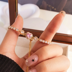 Elegant adjustable gold bracelet with pink heart-shaped crystal and white zircons