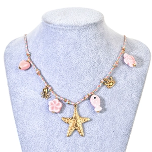 Nautical charm necklace with starfish and turtle pendants on a colorful braided rope