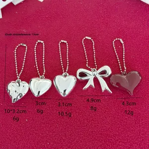 Detail of silver alloy heart and bow keychains with dimensions and ball chain view