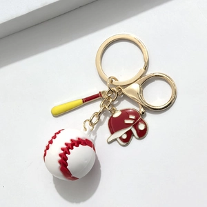 Détail d'un porte-clés sport avec breloques de baseball, batte et casque sur fermoir doré