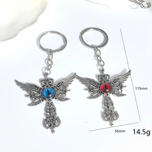 Porte-clés croix ailée gothique avec yeux de démon en finition argent vintage