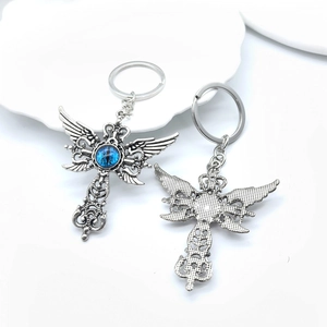 Vue détaillée du porte-clés croix ailes en argent vintage avec œil bleu sur céramique