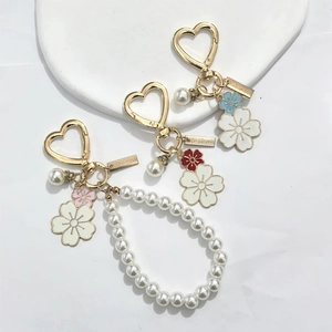 Detailed macro view of gold heart hooks, faux pearls, and colorful floral charms on a tray