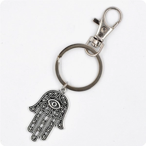 Détail d'un porte-clés Main de Fatma en argent avec œil bleu et motifs en filigrane