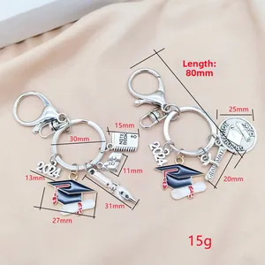Detailed view of silver alloy graduation keychain set with academic cap and diploma charms