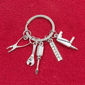 Vue détaillée d'un porte-clés en métal avec mini pince, règle et outils de bricolage