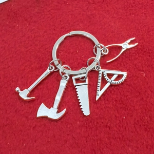 Détail d'un porte-clés en métal avec des outils miniatures sur un fond en feutre rouge