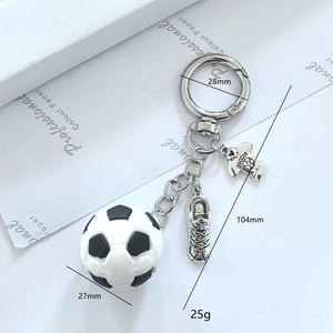 Detail of soccer keychain with 3D ball, metal cleat, and SOCCER jersey pendant charms