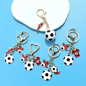 Detail view of gold soccer keychains with enamel football and sports charms