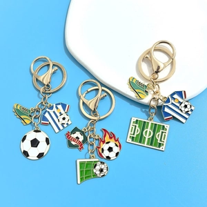 Detailed view of soccer keychain charms with jersey and football in gold metal finish