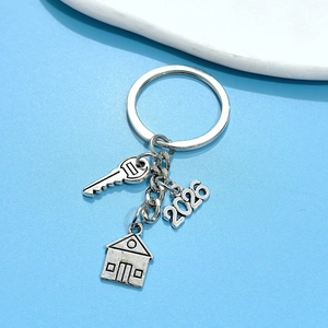 Detailed close-up of 2026 house and key charms on a silver metal keychain gift