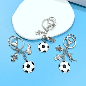 Detail of soccer keychains with football shoes and jerseys on a blue background