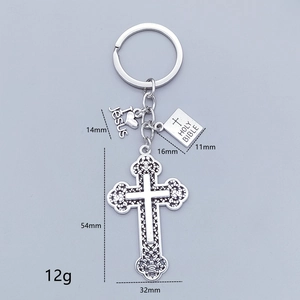 Macro view of religious key ring with silver cross, Jesus heart, and Holy Bible charms
