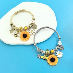 Close-up of sunflower and bee charms on stainless steel beaded bracelets for women
