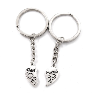 Silver puzzle heart keychains for best friends with engraved script on white background