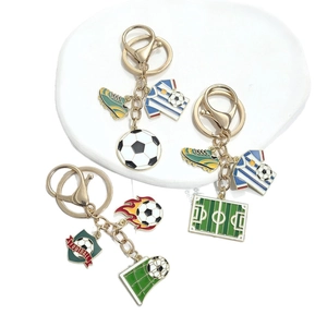 Three football themed keychains with golden metal rings and colorful enamel pendants