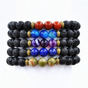 Detailed macro view of 5-piece natural lava stone beaded bracelets with colorful gemstones