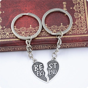 Close-up of split heart Best Friend keychains in vintage silver finish on red book