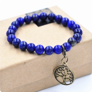 Pulsera de cuentas de lapislázuli con dije del Árbol de la Vida en bronce sobre caja