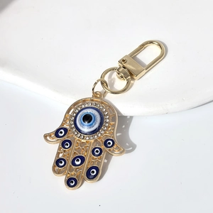 Macro detail of Hamsa Hand keychain with blue evil eye beads and sparkling crystals