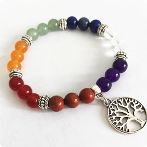 Vista macro de pulsera de cuentas chakra de 8mm y colgante plateado del árbol de la vida