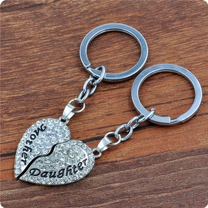 Detail of silver heart puzzle keychains for mother and daughter with white rhinestones