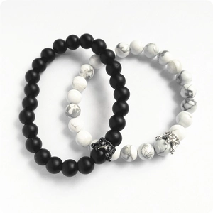 Détail de bracelets couronne noirs mats et turquoise blanche pour couples avec micro-strass