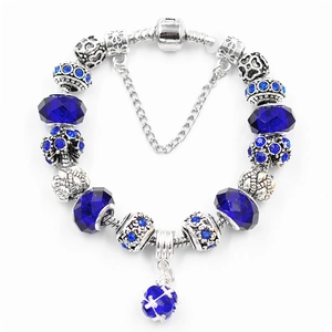 Macro view of blue crystal charms and silver snake chain with barrel clasp detail