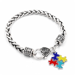 Détail du bracelet en chaîne tressée avec fermoir cœur et pendentif puzzle coloré