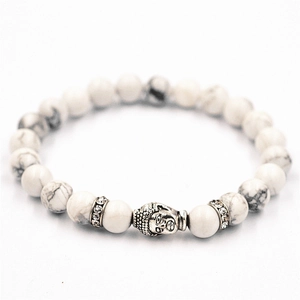 Vista detallada de pulsera de cuentas blancas con dije de cabeza de Buda plateado