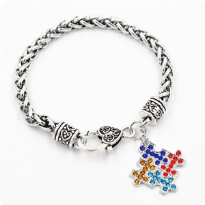 Gros plan du pendentif puzzle en argent avec cristaux colorés et fermoir mousqueton sculpté