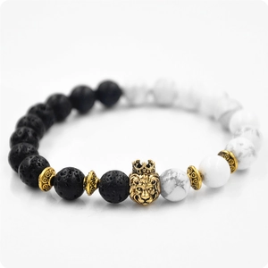 Macro view of lava rock and white turquoise beads with a golden lion crown charm