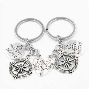 Close-up of split heart compass keychains featuring the engraved phrase no matter where