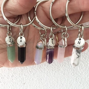 Vue macro de six porte-clés en colonnes de cristal hexagonal avec pendentifs alphabétiques